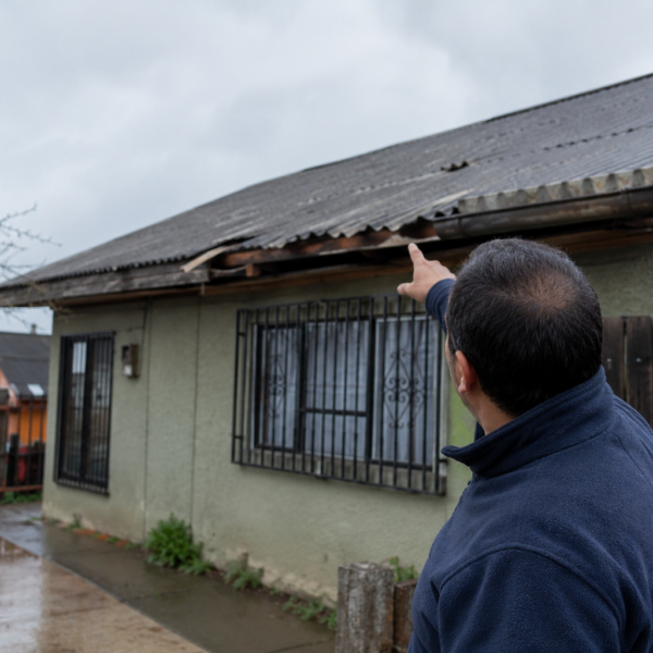 Persona inspeccionando una vivienda tras las lluvias para detectar filtraciones y daños estructurales.