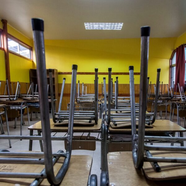 Sala de clases con las sillas sobre la mesa, por suspención de clases.