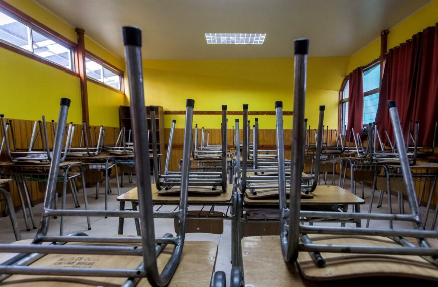 Sala de clases con las sillas sobre la mesa, por suspención de clases.