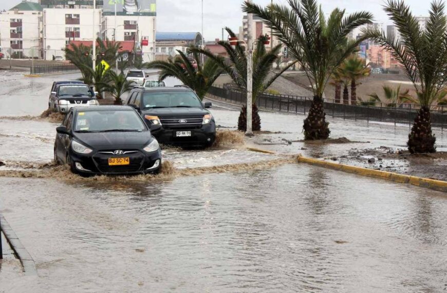 Vehículos circulan por calles anegadas tras intensas lluvias en Antofagasta, en medio de un evento meteorológico que afecta a la región.