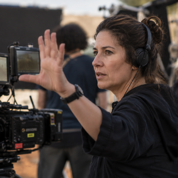 Directora de cine trabaja detrás de una cámara durante el rodaje de una película.