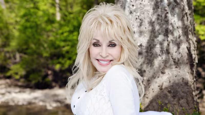 Dolly Parton con su característica cabellera rubia y vestuario brillante, ícono de la música country estadounidense.