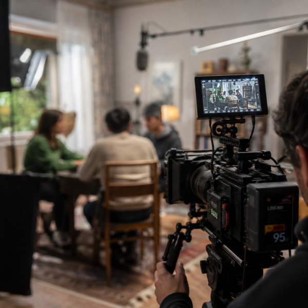 Equipo de producción audiovisual durante el rodaje de una escena, con cámara profesional, iluminación y micrófono en un set de filmación.