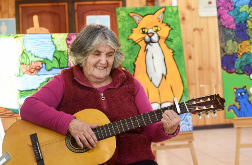 Cantora campesina toca guitarra en la Mateada Cultural con exposición de artes visuales, música campesina y encuentro comunitario.