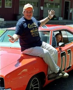 Ben Jones, recordado por interpretar a Cooter Davenport en “Los Dukes de Hazzard”, posa sobre el icónico General Lee.