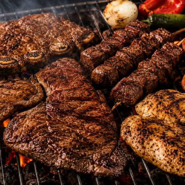 Parrilla con distintos cortes de carne, pollo y cerdo preparada para un asado de Fiestas Patrias