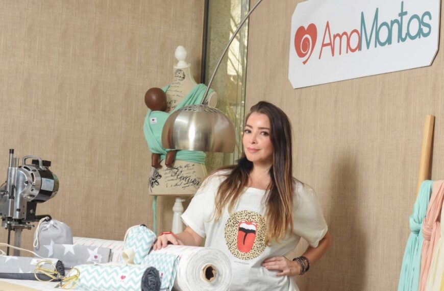 Claudia Alvial posa junto a productos textiles de Amamantas en un taller.