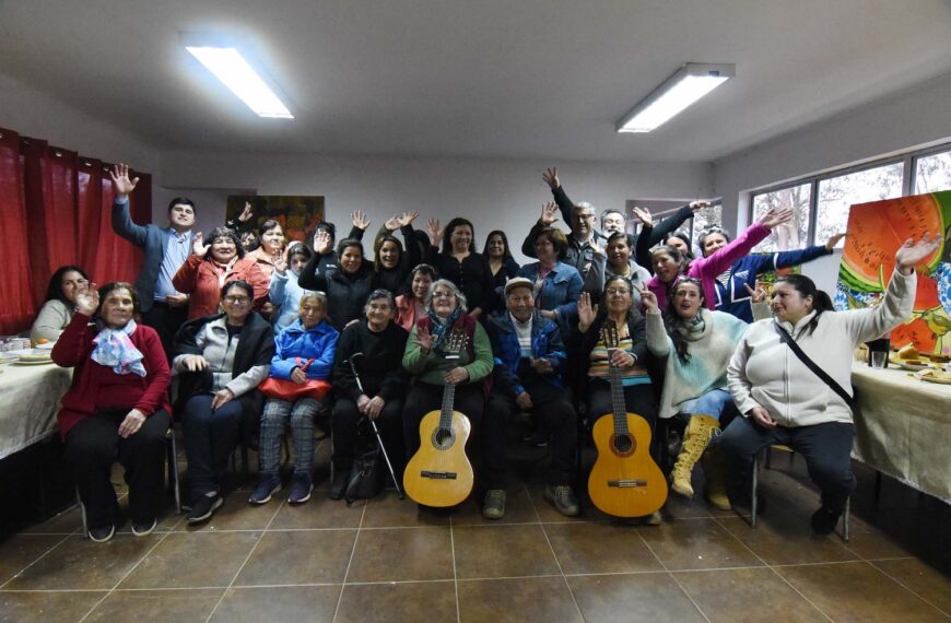 Vecinas, vecinos y artistas posan junto a dos guitarras durante una Mateada Cultural en Canelillo.