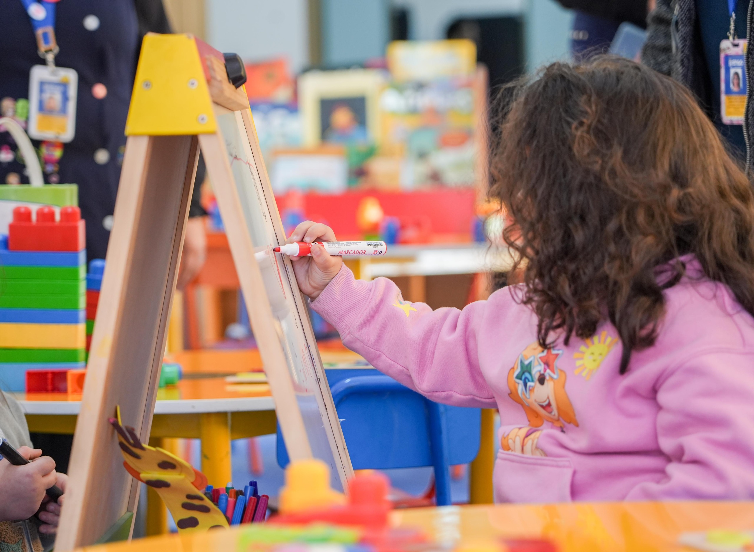 Niña dibuja en una pizarra durante una actividad infantil.