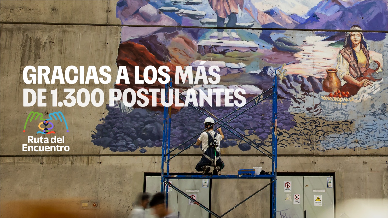 Persona trabaja sobre un andamio frente a un mural de gran formato.
