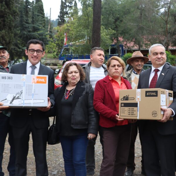 Grupo de propietarios forestales y autoridades posa con cajas de motosierras durante una entrega de maquinaria.