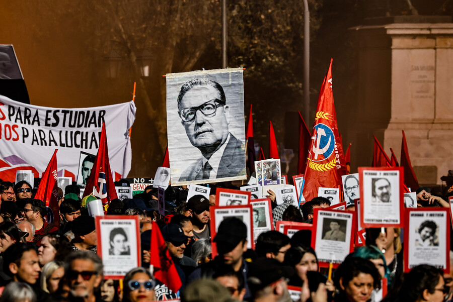 Manifestantes participan en la romería portando fotografías de víctimas de la dictadura y un retrato de Salvador Allende.